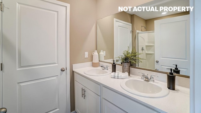 full bath with a sink, double vanity, and a shower