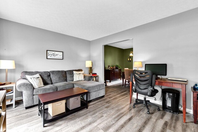 office space with baseboards, a textured ceiling, and wood finished floors