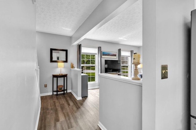 hall featuring baseboards, a textured ceiling, and wood finished floors