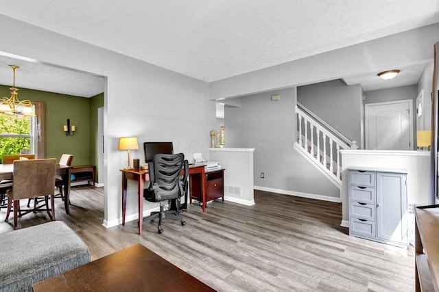office area with a textured ceiling, a chandelier, wood finished floors, and baseboards