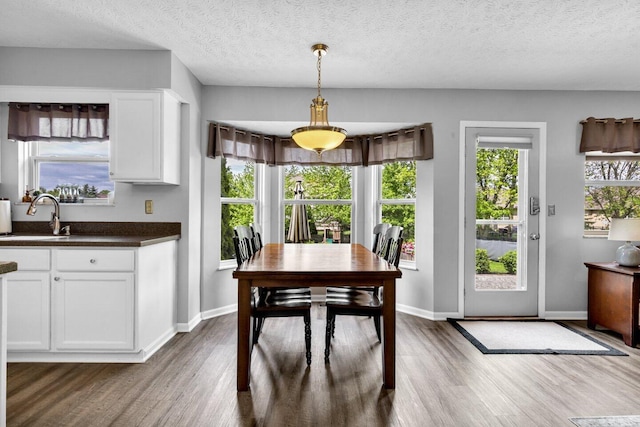 dining area with baseboards, dark wood finished floors, and a textured ceiling