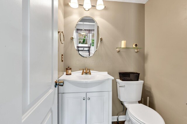 half bath featuring toilet and vanity