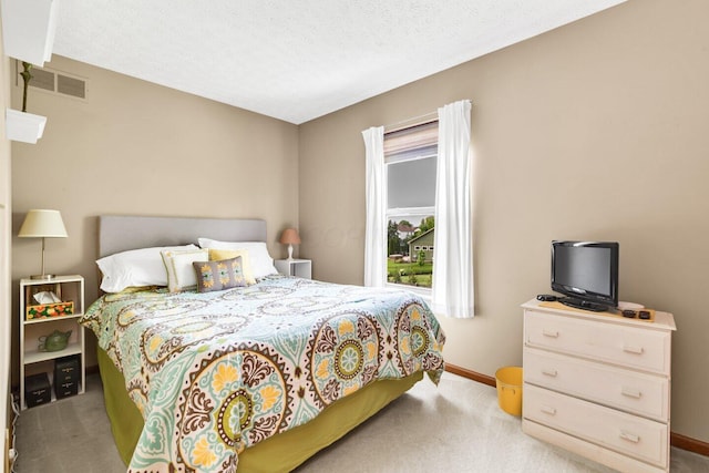 carpeted bedroom featuring baseboards and visible vents