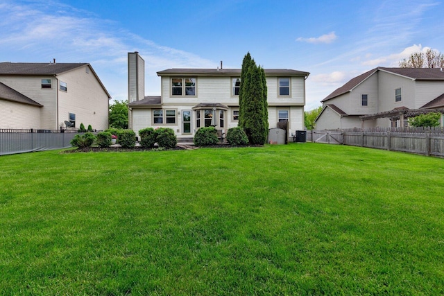 back of house with a fenced backyard, central AC, a chimney, and a lawn