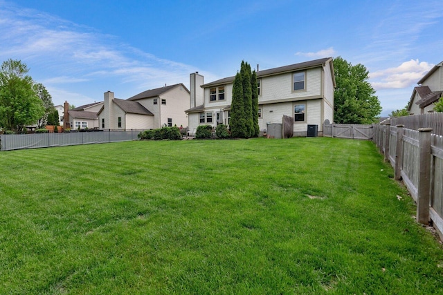 rear view of property featuring a fenced backyard, cooling unit, a yard, and a residential view