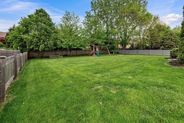view of yard with a playground and a fenced backyard