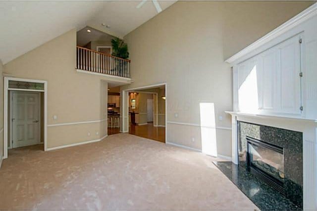 1139 Cross Creeks Rdg, Pickerington, OH 43147 - unfurnished living room featuring high vaulted ceiling, carpet, a tiled fireplace, and baseboards