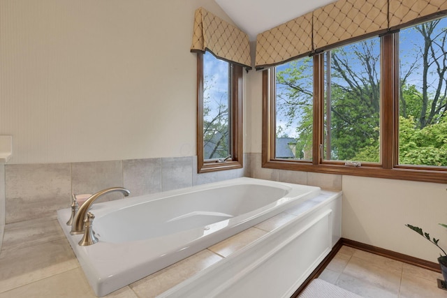 full bath featuring a bath, tile patterned floors, baseboards, and lofted ceiling