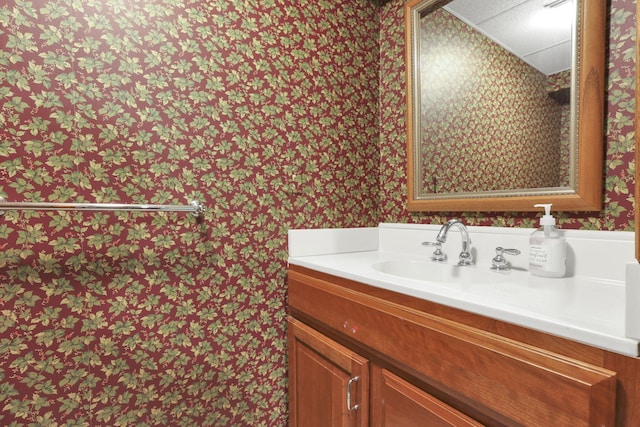 bathroom featuring wallpapered walls and vanity