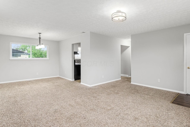 unfurnished living room featuring a textured ceiling, baseboards, and light colored carpet
