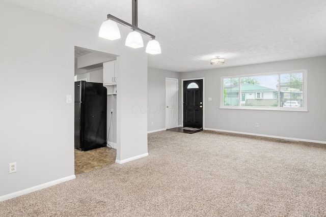 interior space featuring a textured ceiling, carpet floors, and baseboards