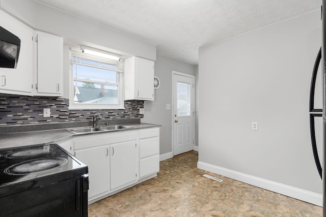 kitchen with a wealth of natural light, decorative backsplash, a sink, and black range with electric cooktop