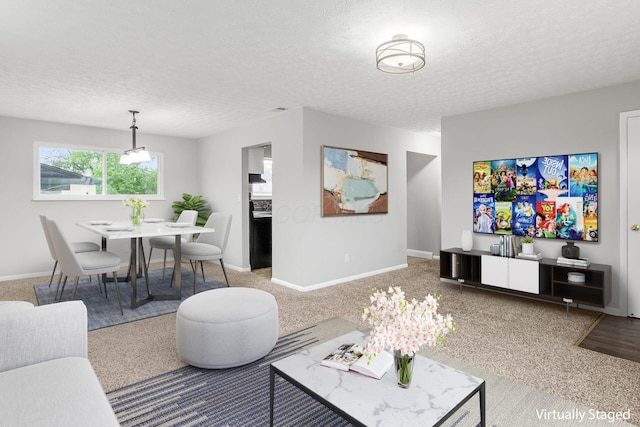 living area with baseboards, carpet floors, and a textured ceiling