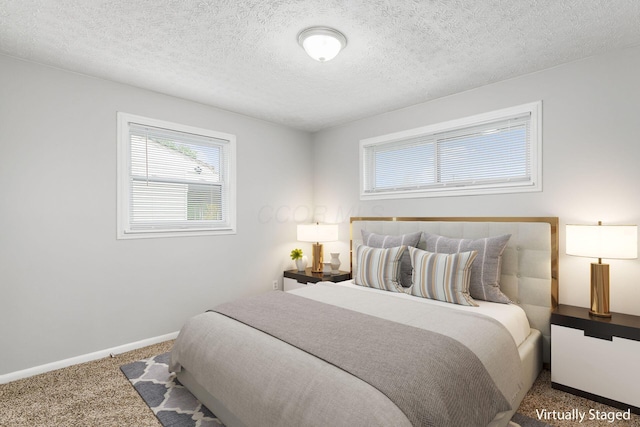 bedroom with baseboards, carpet flooring, and a textured ceiling