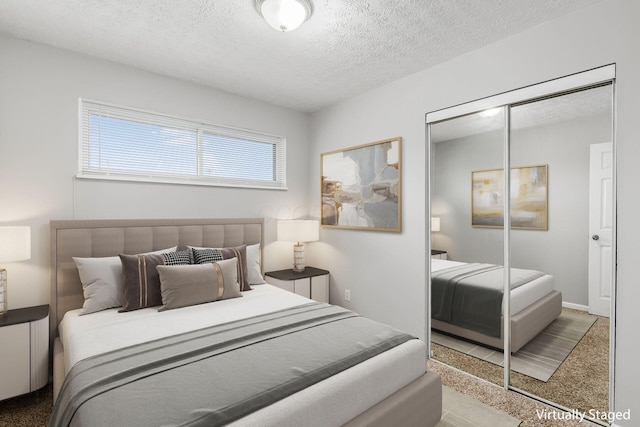 bedroom featuring a textured ceiling, carpet floors, and a closet
