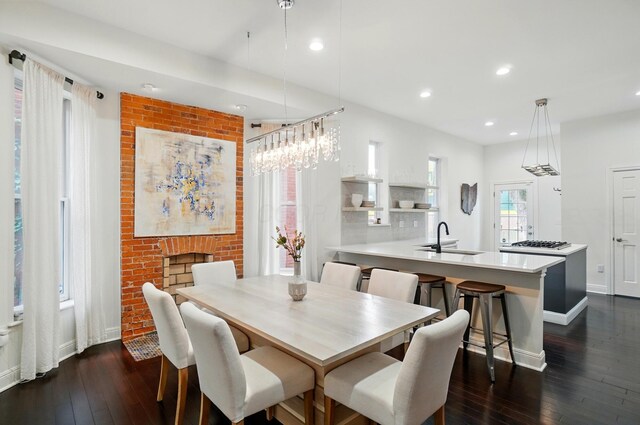 931 Dennison Ave, Columbus, OH 43201 - dining space with dark wood-style flooring, a brick fireplace, baseboards, and recessed lighting
