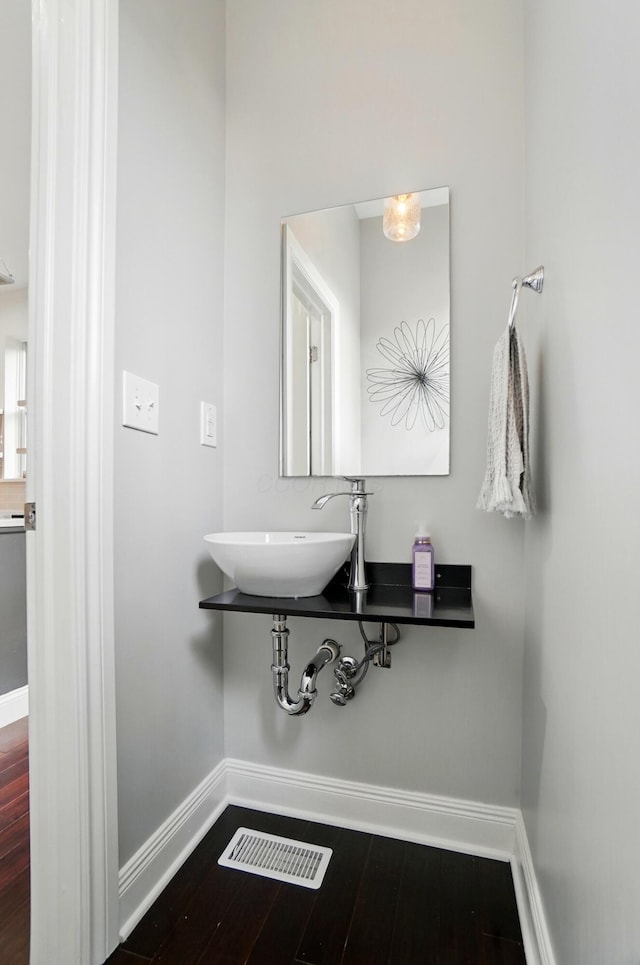 931 Dennison Ave, Columbus, OH 43201 - bathroom featuring a sink, baseboards, visible vents, and wood finished floors