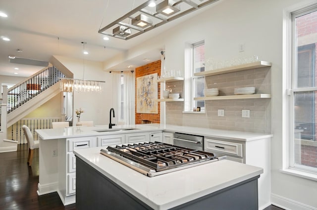 931 Dennison Ave, Columbus, OH 43201 - kitchen with a center island, a sink, a peninsula, stainless steel appliances, and tasteful backsplash