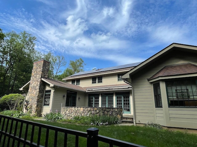 61 Wyddfa Ct, Granville, OH 43023 - view of front facade with solar panels, a chimney, and stone siding