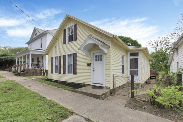 view of front of house featuring a gate, fence, and covered porch