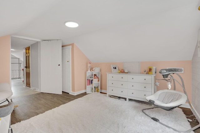 living area featuring lofted ceiling, baseboards, visible vents, and wood finished floors