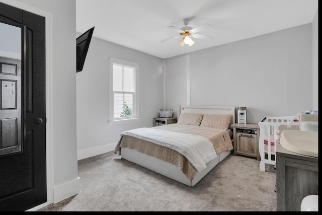 bedroom featuring baseboards, ceiling fan, and light colored carpet
