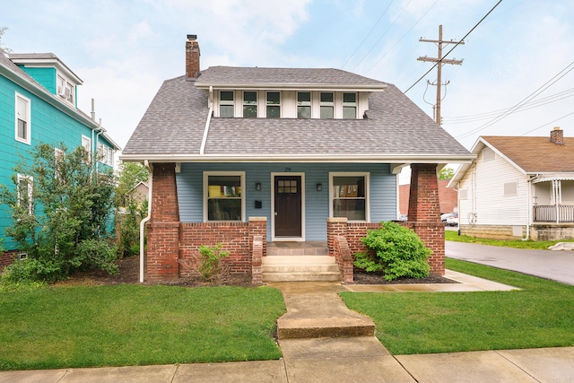 24 Brighton Rd, Columbus, OH 43202 - bungalow-style home with covered porch, a chimney, a front yard, and brick siding