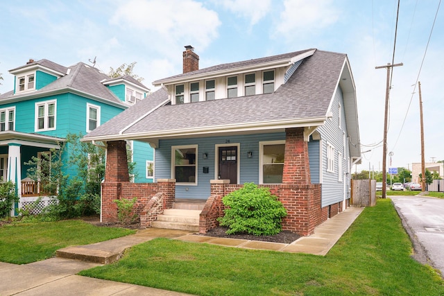 24 Brighton Rd, Columbus, OH 43202 - view of front of home featuring a porch, a front lawn, brick siding, a chimney, and a shingled roof