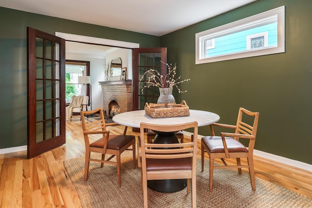 24 Brighton Rd, Columbus, OH 43202 - dining area featuring light wood-style floors, a fireplace, baseboards, and french doors