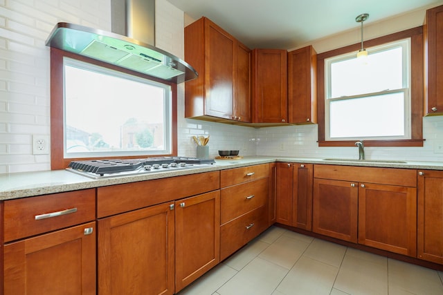 24 Brighton Rd, Columbus, OH 43202 - kitchen with exhaust hood, a sink, brown cabinetry, stainless steel gas cooktop, and backsplash
