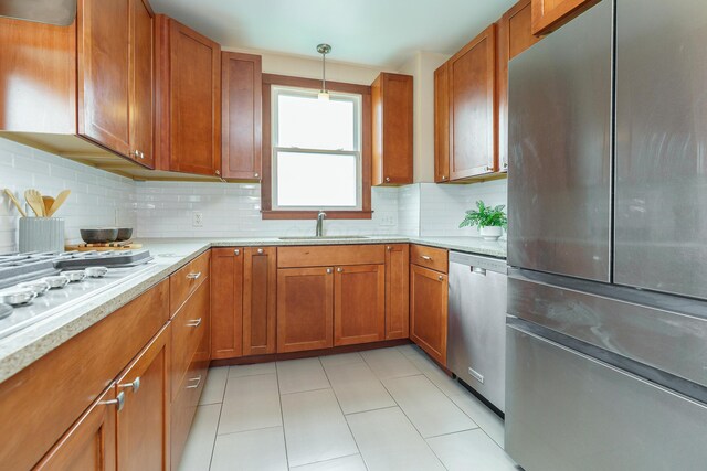 24 Brighton Rd, Columbus, OH 43202 - kitchen with appliances with stainless steel finishes, a sink, brown cabinetry, decorative backsplash, and light tile patterned floors