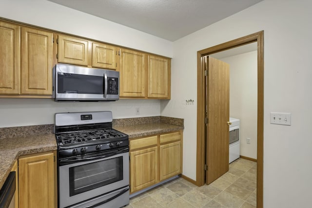 6010 Acropolis Way, Columbus, OH 43231 - kitchen with appliances with stainless steel finishes, dark countertops, washer / dryer, and baseboards