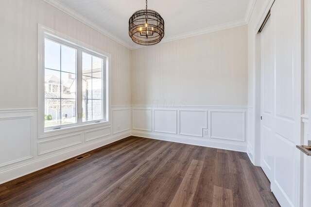 1473 Dogwood Loop, Powell, OH 43065 - unfurnished dining area featuring a chandelier, dark wood-style floors, ornamental molding, a decorative wall, and wainscoting