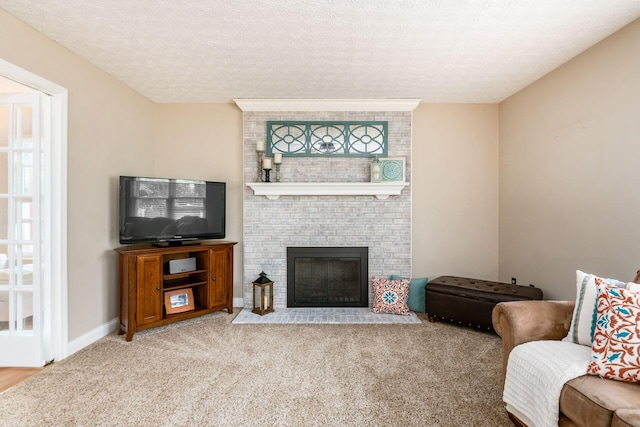 carpeted living area featuring a fireplace, a textured ceiling, and baseboards