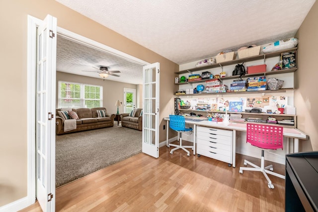 office with french doors, wood finished floors, a textured ceiling, baseboards, and a ceiling fan