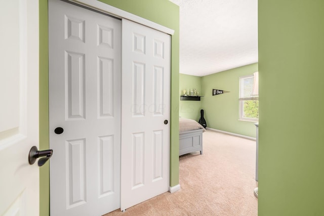 hallway with light carpet and baseboards