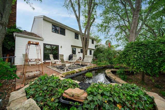 back of property featuring a garden pond