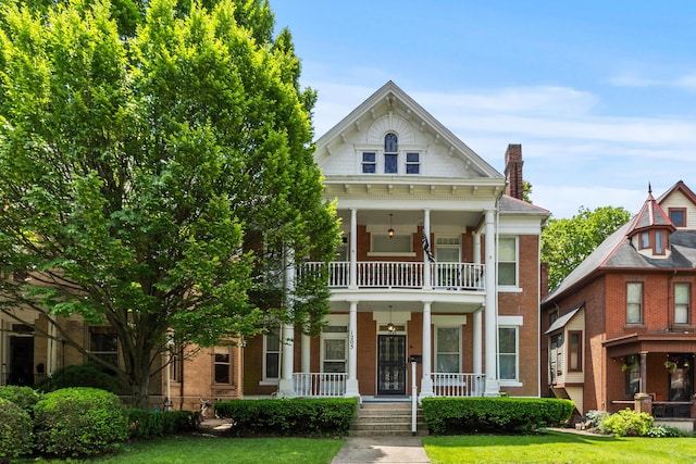 1205 Bryden Rd Unit 7, Columbus, OH 43205 - neoclassical / greek revival house featuring covered porch, a balcony, a front lawn, a chimney, and brick siding