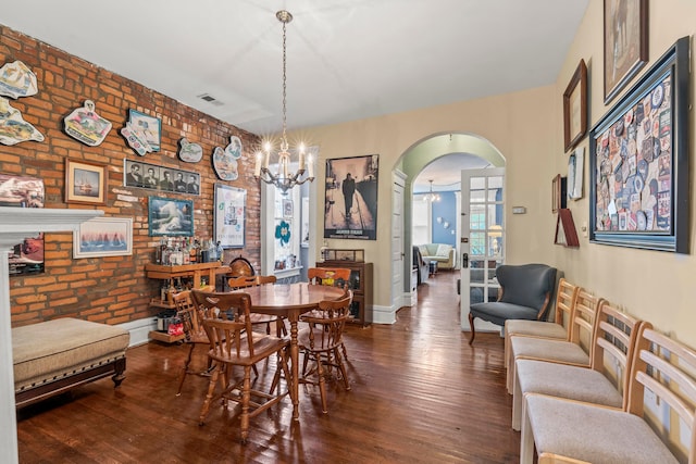 1205 Bryden Rd Unit 7, Columbus, OH 43205 - dining room with a chandelier, arched walkways, hardwood / wood-style floors, brick wall, and baseboards
