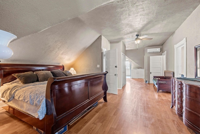 1205 Bryden Rd Unit 7, Columbus, OH 43205 - bedroom featuring a wall unit AC, wood finished floors, a textured ceiling, vaulted ceiling, and a ceiling fan
