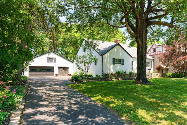 1660 Ridgeway Pl, Columbus, OH 43212 - tudor-style house with a detached garage, a front yard, an outbuilding, and a chimney