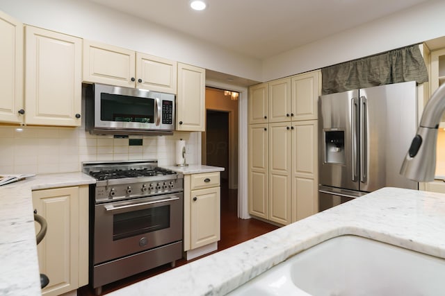 1660 Ridgeway Pl, Columbus, OH 43212 - kitchen featuring stainless steel appliances, cream cabinets, light stone counters, and recessed lighting