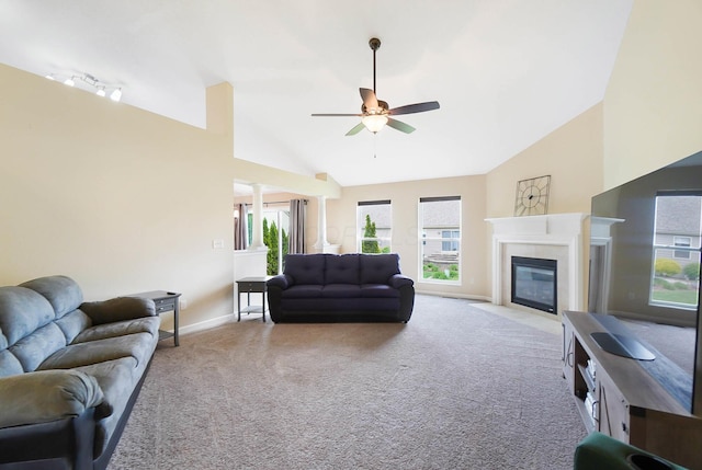 carpeted living room with a ceiling fan, baseboards, a fireplace, and high vaulted ceiling