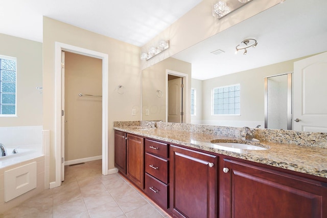 bathroom with plenty of natural light, double vanity, tile patterned flooring, and a bath