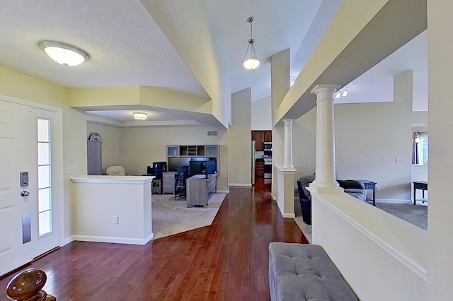 entrance foyer with ornate columns, wood-type flooring, baseboards, and a textured ceiling