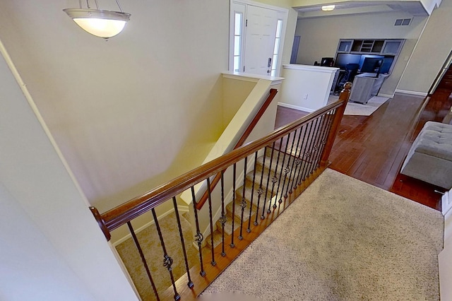 stairs featuring wood finished floors and baseboards