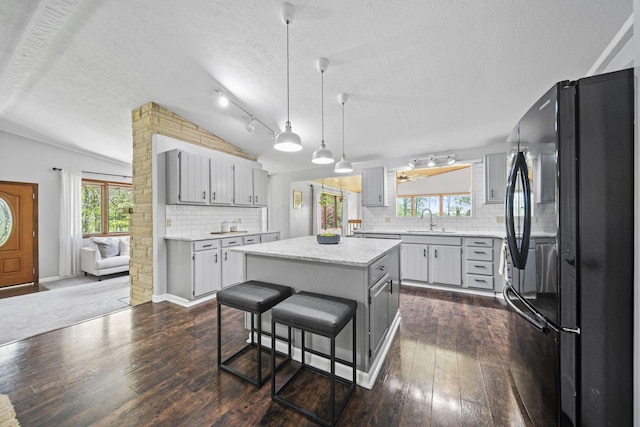 2825 Kings Corners Rd E, Mansfield, OH 44904 - kitchen with freestanding refrigerator, a sink, vaulted ceiling, dark wood-type flooring, and decorative backsplash