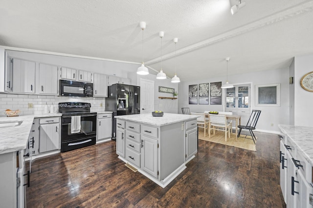 2825 Kings Corners Rd E, Mansfield, OH 44904 - kitchen featuring black appliances, dark wood-style flooring, backsplash, a center island, and light stone countertops