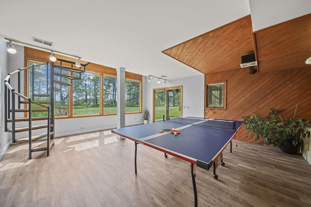 2825 Kings Corners Rd E, Mansfield, OH 44904 - rec room with rail lighting, wood walls, wood finished floors, and baseboards