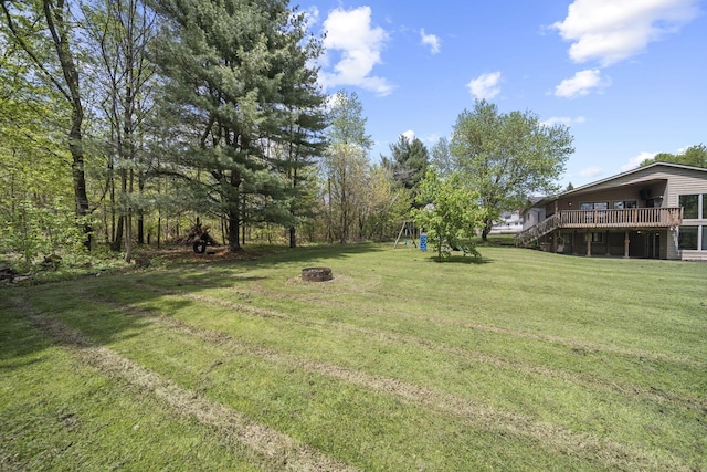 2825 Kings Corners Rd E, Mansfield, OH 44904 - view of green lawn with an outdoor fire pit, a wooden deck, and a playground